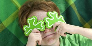 rödhårig och fräkne ansikte irländsk pojke troll med shamrock cookies över ögonen leende irländskt barn bär grönt på st patricks se ljusbord nedan för mer semestermat och människor bakgrunder