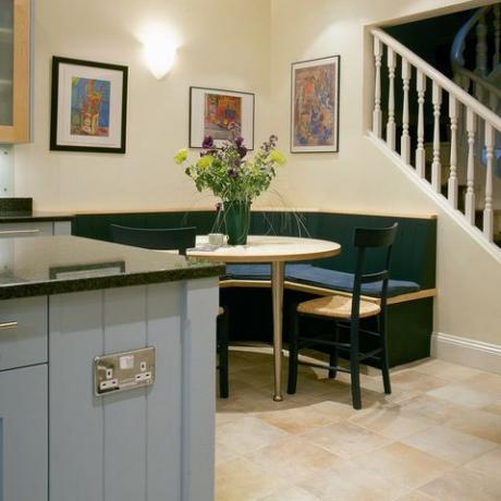 hörnbankettsittplatser vid bordet i modernt kök med ljusblå enhet och trappa till övervåningen