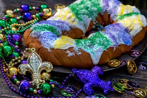 king cake omgiven av mardi gras dekorationer