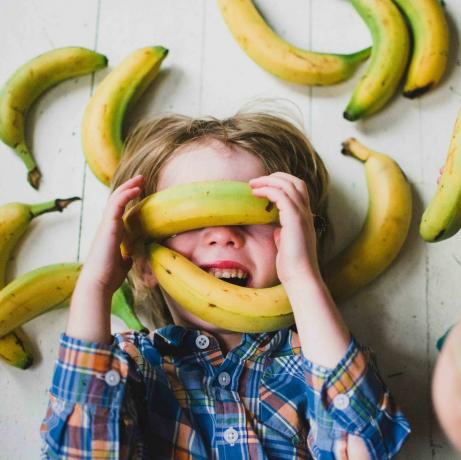 Barn (2-3, 4-5) täckta av bananer