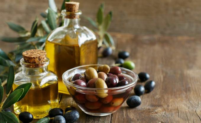 Olivolja och oliver på trä bakgrund