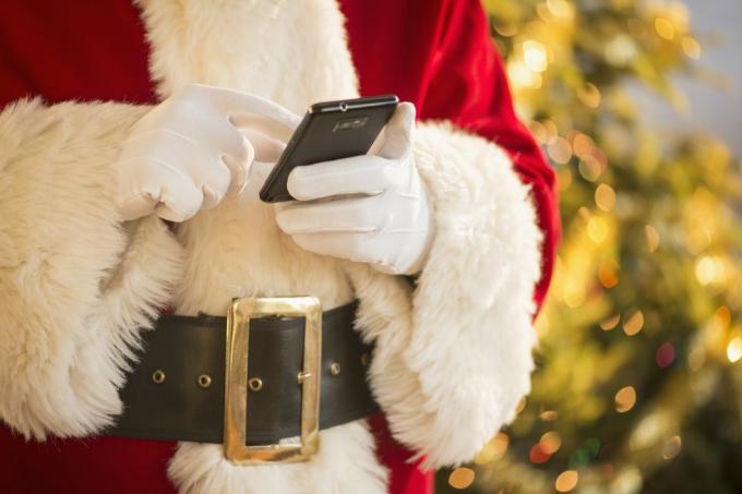 Jultomten håller mobiltelefon