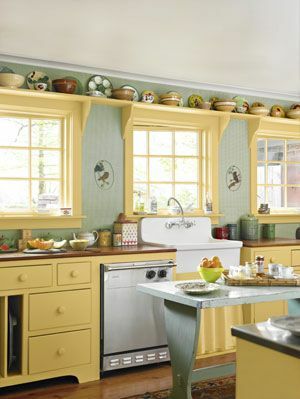 kök med gröna väggar och gula skåp