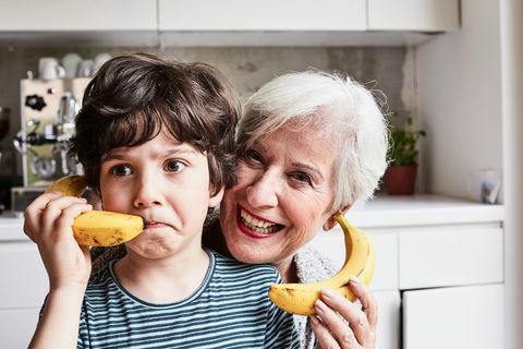 mormor och barnbarn busar, använder bananer som telefoner, skrattar