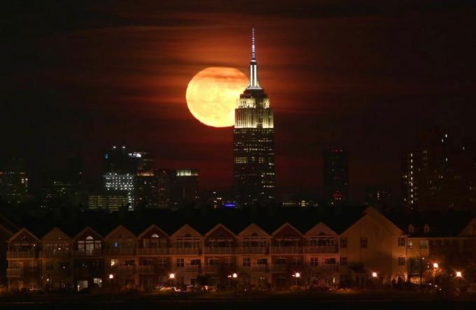 Fullmåne stiger bakom Empire State Building i New York City