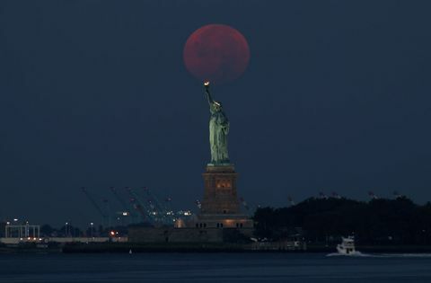 Fullmånen sätter bakom Frihetsgudinnan i New York City