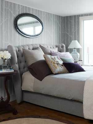 grått sovrum med klädda huvudgavel