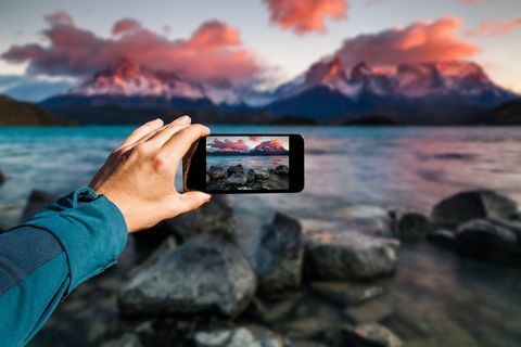 Fotografera med smartphonen i handen. Resekoncept. Torres del Paine, Chili
