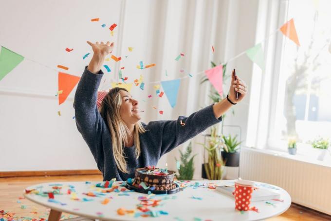 en kvinna, vacker ung kvinna som använder smart telefon för selfie, hon firar sin födelsedag ensam hemma