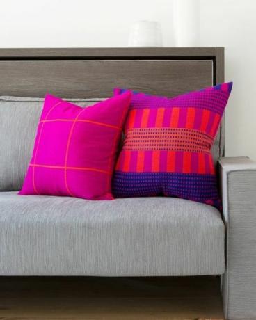 neonrosa kuddar på grå soffa